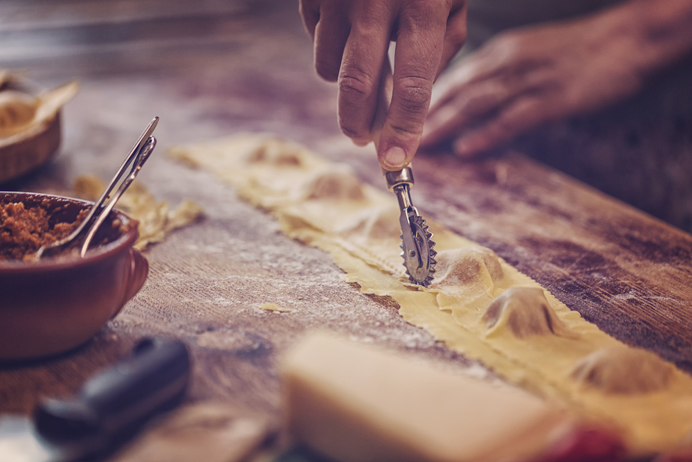 Person cutting fresh pasta ravioli 